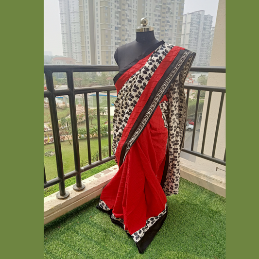 Pure Cotton Designer Sari with half adorned in intricate hand block print patterns of half white and black, while the other half showcases a rich red self-design cotton fabric. Paired with a matching blouse piece,