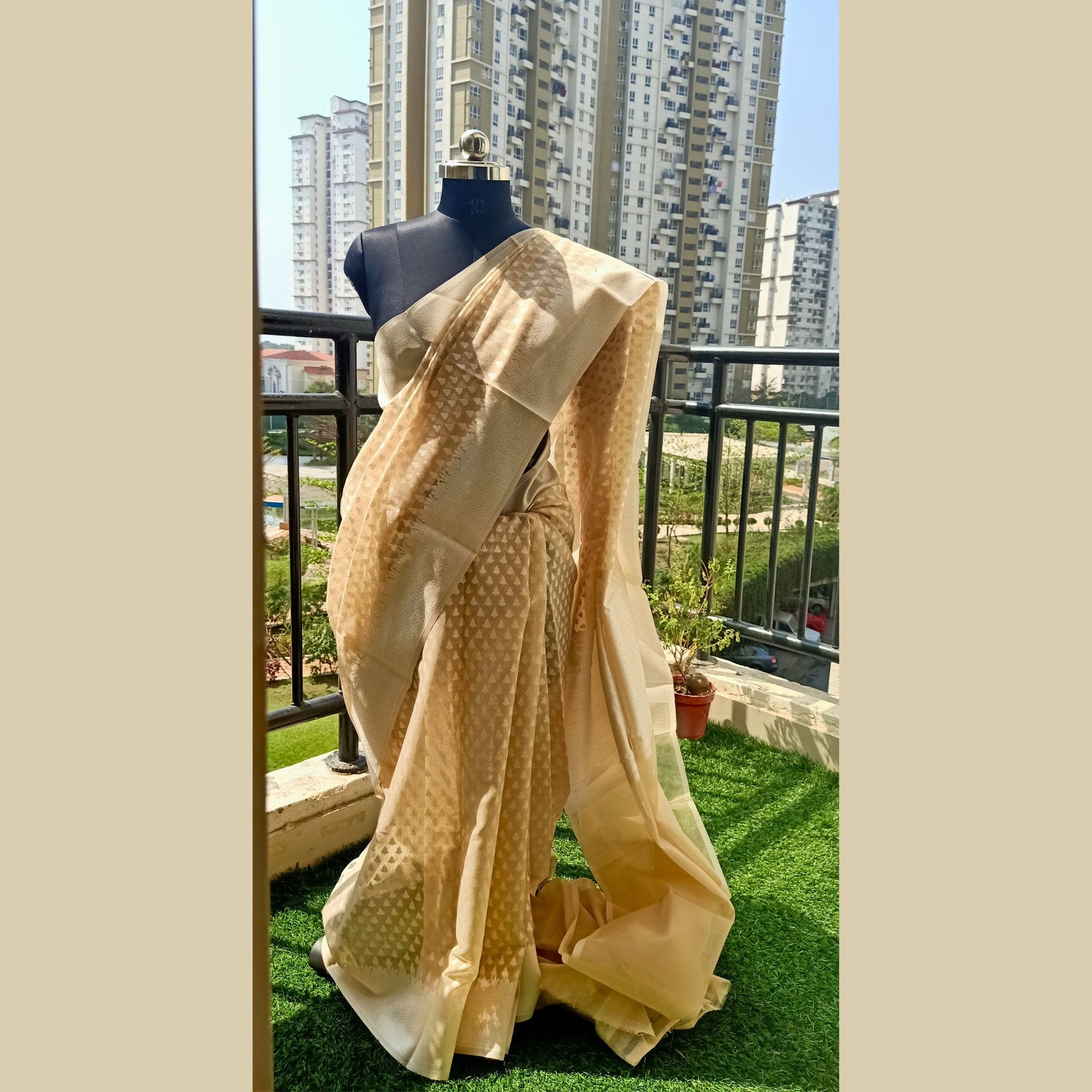 Benaras Soft Dhakai Saree in enchanting beige colour. Delicately adorned with intricate white boti detailing, this saree exudes timeless charm. Complete with a matching blouse piece, it's perfect for adding a touch of grace to any occasion - Fabcentra