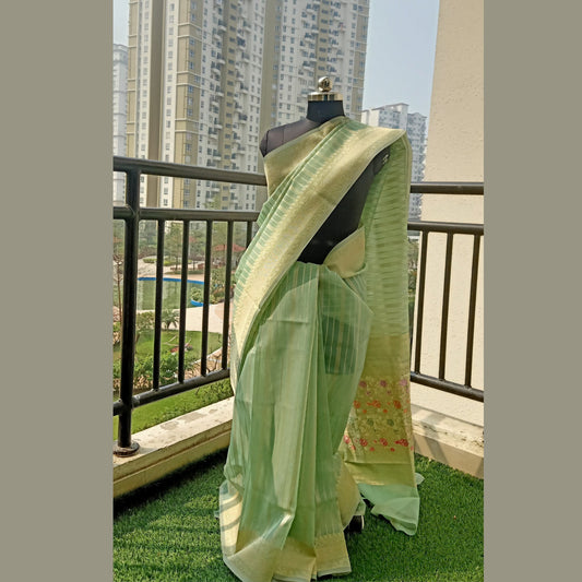 Pastel Green Organza Saree featuring zari strips and intricate embroidery on the border and pallu. Paired with a matching pastel green blouse piece for a cohesive ensemble. - Fabcentra
