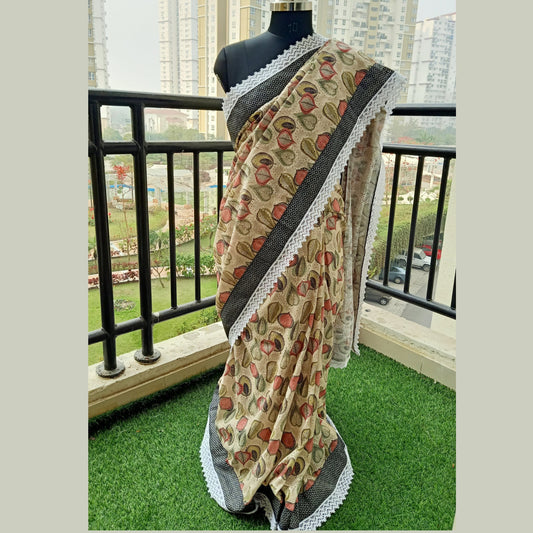 Beige-colored sari, crafted with pure hakoba fabric, featuring intricate detailing throughout the body. Adorned with delicate light ash and black borders, complemented by elegant white lace accents. Complete with a matching blouse piece